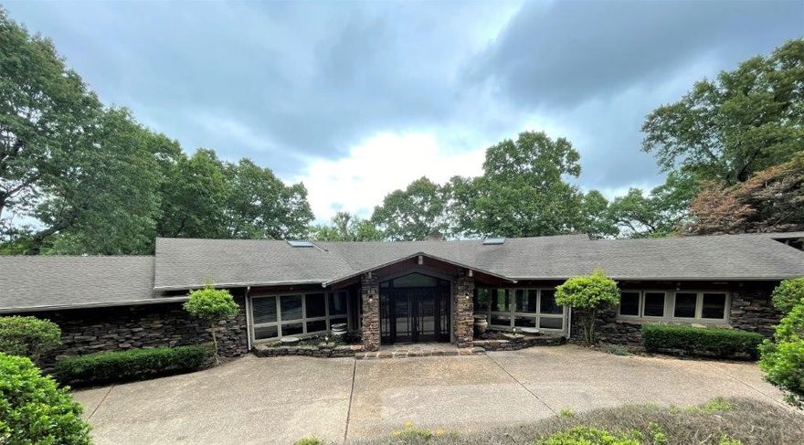 Custom lakefront home on Lake Windsor with the potential to make it your own one-of-a-kind retreat in Bella Vista.  Ready to be finished out and completed with your own personal touch, this unique home is situated on 4 acres +/-, has 589 feet +/- of shoreline, and is located at the end of a cul-de-sac with sprawling views of the lake. Architecturally stylish throughout with large floor to ceiling windows and exposed beam and wood ceilings.  An entertainer’s dream:  soaring ceilings, multiple living areas, gourmet kitchen, wet bar, floor to ceiling stone, water feature, and media room in home; outside you will enjoy your own in-ground pool, pool house featuring 2 bathrooms & kitchen, private boat dock and more. Other features include split floor plan, massive windows, media room, office, multiple outdoor areas, green house, mature landscaping, circular drive, gated driveway, professionally landscape and abundant storage. Close to hiking/biking trails.  Great location and with easy access highway.  Home is sold AS-IS