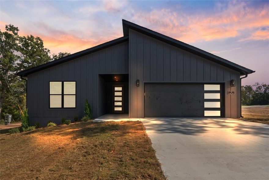 Modern new construction home on a flat .45-acre wooded corner lot. Close to Loch Lomond & Highlands Golf Course and less than 20 minutes from downtown Bentonville! This stunning residence features 3 beds, 2 baths, a waterfall kitchen island, premium black stainless steel appliances including a gas range, 3 cm quartz countertops, a walk-in pantry, custom cabinets, & high-end finishes throughout. The inviting living space boasts 10-foot ceilings and a beautiful fireplace, while the oversized custom tile shower adds a touch of luxury to the primary bath. Step outside to the large covered porch perfect for relaxation and entertaining. This is one you won't want to miss!