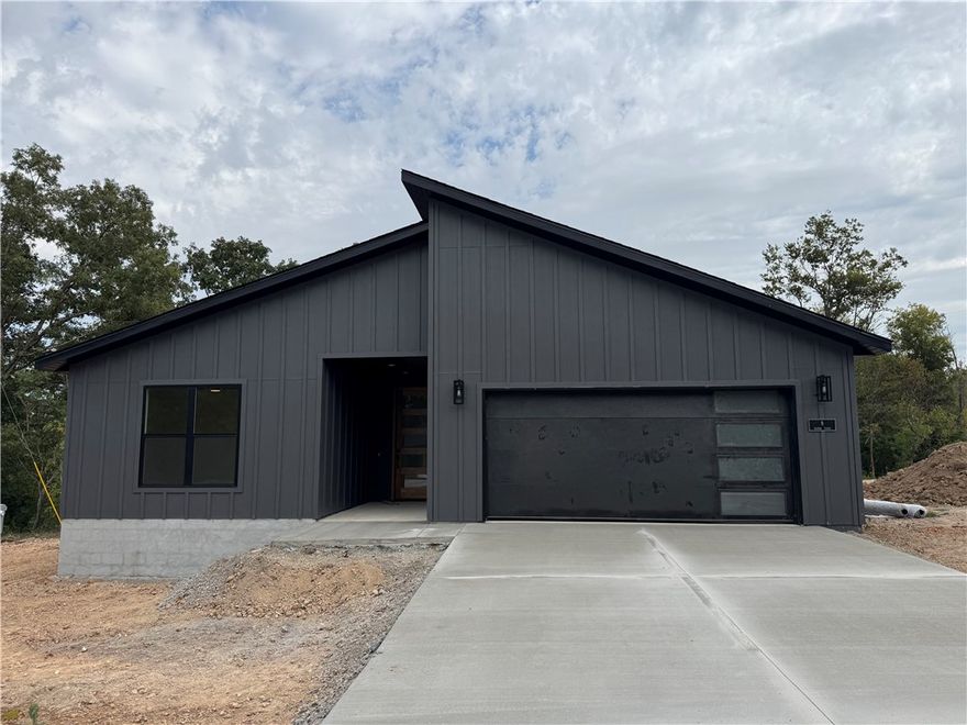 Professional photos coming soon! COMPLETION DATE OF 10/17. Modern new construction home on a flat .45-acre wooded corner lot. Close to Loch Lomond & Highlands Golf Course and less than 20 minutes from downtown Bentonville! This stunning residence features 3 beds, 2 baths, a waterfall kitchen island, premium black stainless steel appliances including a gas range, 3 cm quartz countertops, a walk-in pantry, custom cabinets, & high-end finishes throughout. The inviting living space boasts 10-foot ceilings and a beautiful fireplace, while the oversized custom tile shower adds a touch of luxury to the primary bath. Step outside to the large covered porch perfect for relaxation and entertaining. This is one you won't want to miss!