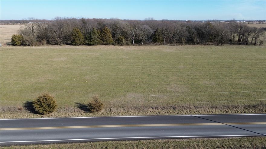 Round Prairie Near Gentry 26+ ACRES of level productive grassland with a small portion of wooded (an old orchard), 1 pond, fenced 3 sides, paved road!
