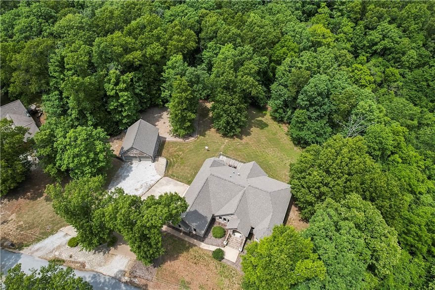 Stretch out and enjoy this expansive home with mature trees surrounding your home! Beautiful views out every window!  Bring your toys and hobby equipment! (The detached 26'x30' shop has 10' ceilings.) Enjoy country life without POA restrictions. Well built home has walk out basement, multiple living spaces, and a "safe" room. New roof 2020, wired for generator, updated appliances. A Bella Vista membership lot will convey with acceptable offers (for amenity use) 3 bdrm septic system.