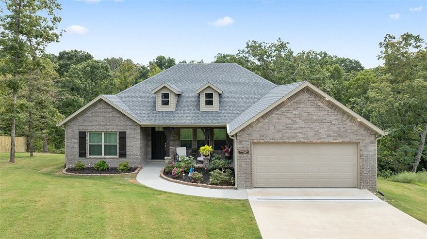 Built in 2022 with a focus on craftsmanship and design, this custom home blends refined finishes with everyday comfort. Tucked away on a quiet cul-de-sac, this meticulously maintained, turn-key home is just minutes from Branchwood Recreation, Loch Lomond Lake, Lake Pointe Marina, golf courses, dining, scenic hike and bike trails, and all the everyday amenities Bella Vista has to offer. Featuring an ideal split floorplan, the interior offers vaulted ceilings, recessed lighting, timeless ceramic tile flooring, and a statement brick fireplace. The eat-in kitchen includes quartz countertops, a large island, pantry, stainless steel appliances, and ample cabinet space. Brick exterior with professional landscaping, French drains, and an epoxy-coated garage floor, front porch and walkway, add both style and function. The fully fenced, tiered backyard offers space to relax or entertain, with a covered deck and TV mount for effortless outdoor living.