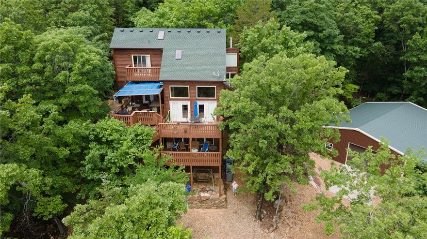 Family lake house with incredible views, fully furnished. This unbelievable property comes with 4 fully furnished bedrooms, main-level kitchen, and functional lower-level kitchenette. 3 full baths—one on each level. Plenty of space and rooms! 3-level deck with gorgeous views. A detached 6-car garage with 2 mini-splits to keep it heated and cooled, comes with a car lift. Community boat slip included. Household items remain subject to seller’s list of personal items. Newer roof and cedar siding completely refurbished. A great personal residence or vacation home.