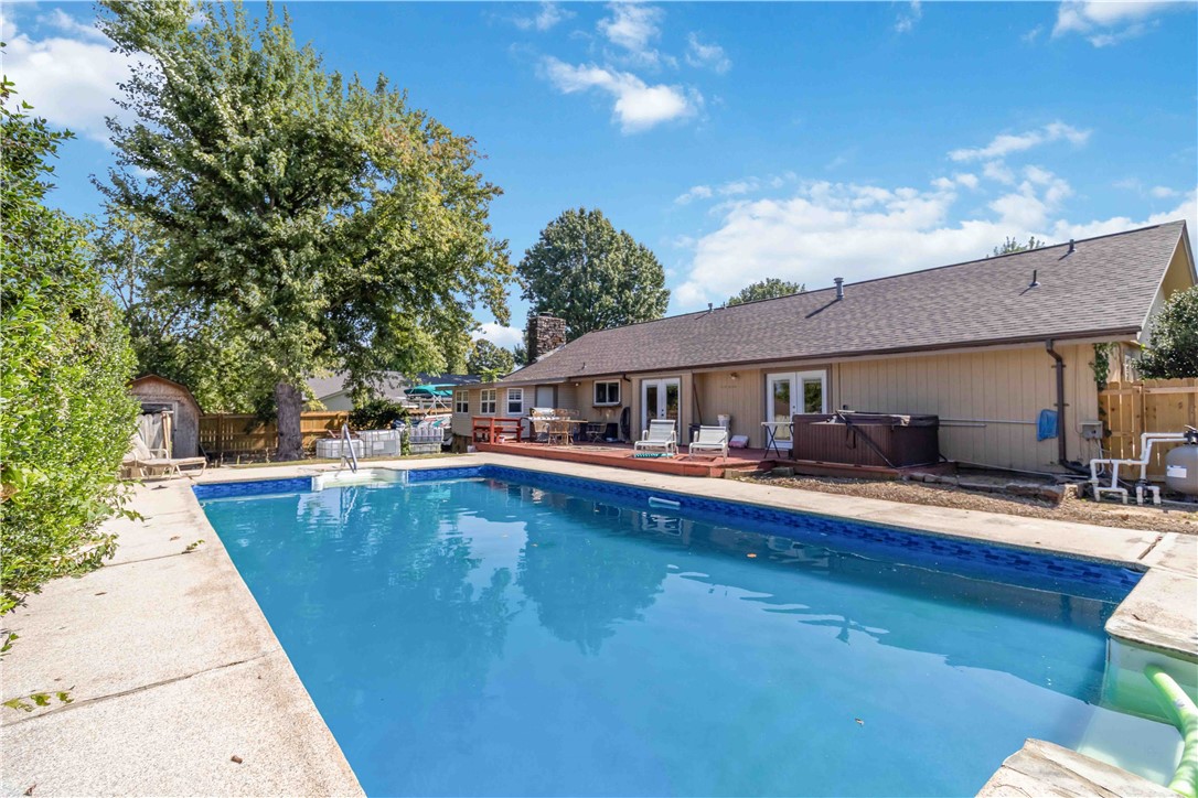 Charming 3 bed, 2 bath home in a prime location near the trail system, Walmart Store #1, and tucked into a quiet, established neighborhood. Offering approx. 1,838 sq ft, this home features an in-ground pool with new liner (July 2025) and a hot tub that can convey. Recent updates include a roof less than 2 years old, LVP flooring (April 2025), all new windows (under 5 yrs), and new hot water heater (Sept 2023). The kitchen boasts granite countertops, gas stove (convertible to electric), and a 2022 garbage disposal. Fridge, washer, and dryer are negotiable. The family room highlights a rock wood-burning fireplace, adding warmth and character. Additional features include HVAC serviced annually (approx. 15 yrs old), attached unfinished storage, detached storage shed, and a brand-new 305 ft fence (2025).
