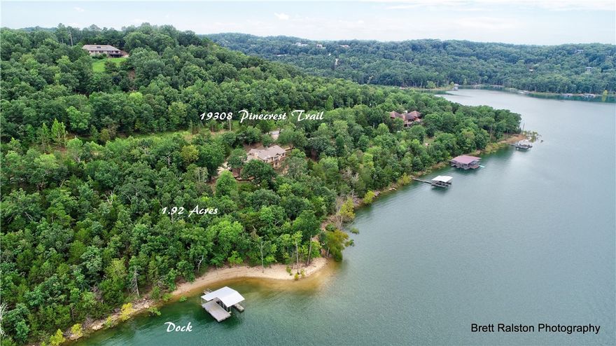 Breathtaking panoramic views from every room of Beaver Lake. This home sits on nearly 2 acres of land, in a peaceful setting with trees, wildlife, and friendly neighbors close by. This home comes with a private beach, private boat & swim dock, detached 32x21 shop, with what seems like an endless outdoor space to enjoy it all. The home has been recently renovated throughout. Large Chef's Kitchen with hardwood floors and KitchenAid built-in refrigerator. Master bedroom with heated tile floors and large walk-in shower. 25x25 screened porch w/cast iron grill and two decks perfect for entertaining and enjoying the scenery. 2nd Living/Game Room/Bar, 2 BRs & an Office in the WO basement. Full house generator for backup power. This home is close to hiking trails and only 2.5 miles from the War Eagle Craft Fair. Come see your next home!