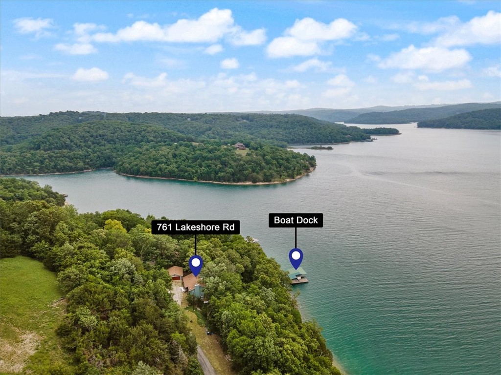 Private w 2 slip boat dock with a lift and swim platform. Year round lake views. New Roof! New Heat and Air system! Covered back patio and cover front porch. 2 car detached garage. Home has lots of extra builtins with specialty woods like Tiger Maple kitchen cabinets w granite countertops. Wood floors are custom made Spaulted Maple and lower level builtins are all Cherry wood. Bedroom and bath on each level. Walkin closet in each bedroom. Seller is recently disabled and moving to be near family. Wired for sound but no speakers. Owner has recently connected to Starlink internet. Additional storage in garage and lower ground level metal carport is for covered storage for lake toys and yard equipment. Seller has handicap permit with atv trail to dock (marked w pink Ribbons.) Lots of paved road frontage for gardening. Home has the potential to be fabulous. Originally 4 bedroom home, family room now, minus 2 Bdrm Family Room can become additional bedroom areas if needed. Builtin desk/work area in lower level.