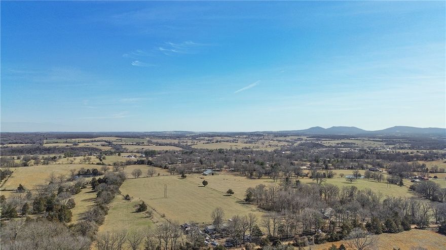 Just outside the Harrison city limits, this 29 acre +/- property offers great views, multiple building sites, and excellent pasture. The land is fully fenced and cross-fenced, featuring two ponds and a corral—perfect for livestock or recreational use. A 70x70 barn is already in place with city water and electricity on site. With no restrictions, the possibilities are wide open. Conveniently located just 1.4 miles from Forest Heights School and only 2 miles from downtown Harrison, this is a rare find that combines space, accessibility, and potential.