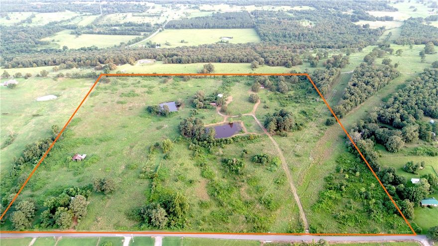 Calling all investors, hobby farmers, or anyone looking to call Arkansas home—this 40 +/- acre property just south of Ozark, AR is loaded with potential! A distressed property with incredible promise, it features three homes, two ponds, and a mix of pasture and timber. The homes need extensive work & TLC, but the land is bursting with character—towering pines, old-growth oaks, pecan trees, and a fenced area that once served as a thriving garden. The main 1,430 +/- sq ft home sits on 1 +/- acre with a detached 24’x24’ garage and has a view of the larger pond. A second 840 +/- sq ft home, also on 1 +/- acre, is ideal for a rental or first-time home. The third structure sits in the southwest corner with scenic views to the north. Utilities include Arkansas Valley Electric, Riversouth Rural Water, and Wave Rural Connect high speed fiber internet (available). The presence of multiple structures, paved road frontage, and utilities already being in place make this AS IS property something worth taking a look at! Call now!
