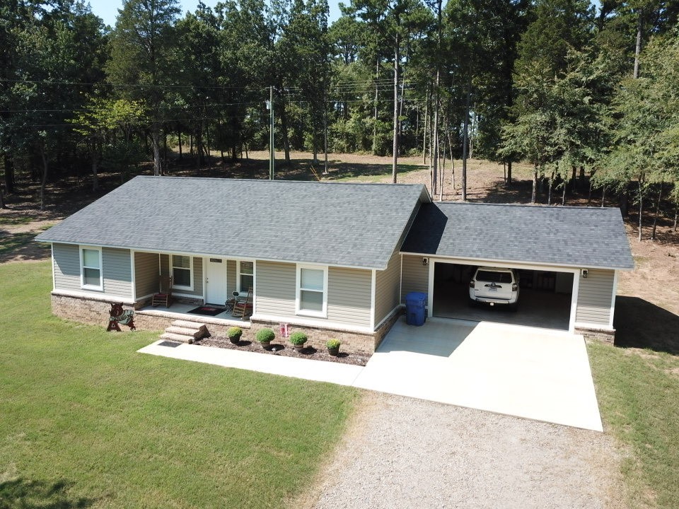 This impressive 1,500 sq ft residence features a two-car garage and is topped with a new architectural shingle roof. The interior boasts luxurious tile flooring throughout, set on a solid concrete slab. The home includes three bedrooms and two bathrooms, each adorned with thick granite countertops in the kitchen and bathroom vanities, as well as in the master walk-in shower, which showcases exquisite tile and granite work. Quality fixtures and faucets enhance the overall aesthetic while custom wood cabinets are featured in the kitchen, bathroom vanities, and laundry area.
Situated on a 3-acre lot, the property is surrounded by a newly sodded grass yard that compliments both the home and shop. The new 30'x30' shop includes an insulated 12' garage door and 12' sidewalls allowing for easy future expansion. It features two windows and is equipped with a new AC and heating window unit. The property has a large gravel circular driveway, accented with brick columns and a new privacy fence. This is a must-see property!