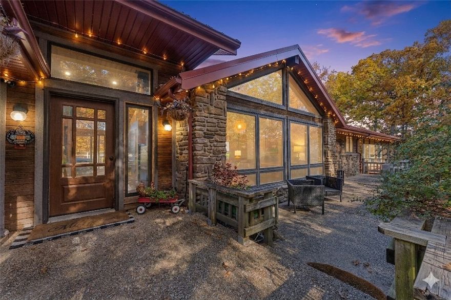 On over 10 acres just outside Rogers, this striking modern home offers breathtaking Ozark Mtn views & a true connection to nature. Designed w/ clean lines & geometric windows reminiscent of F.L. Wright, it blends modern architecture w/ tranquil natural beauty. Main level features gourmet kitchen, cathedral ceilings & 2 lg living areas—ideal for entertaining or everyday living. Lower-level in-law suite w/ private entrance offers flexibility for guests or multi-gen living. Escape light pollution—stargaze by the fire on the large deck or catch panoramic sunset views over a peaceful valley. Fenced, flat front lawn & gardens add charm, while a detached wrkshp & 4-car garage provide practicality & room to create. Multiple bldg sites offer room to expand or customize your dream retreat. Just 12 mi from Hobbs St Park– Conservation Area w/ 50+ mi of trails & Beaver Lake nearby. Monte Ne Boat Ramp & Prairie Creek Marina mins away.Rare blend of design, serenity & adventure in NWA- See attchmnts MLS 1340094 & 1341783