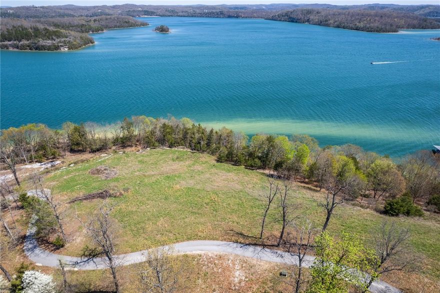 Who wants a home with great views, on Beaver Lake? Oh, and that already has a boat slip in a co-owned dock, and a HydroHoist boat lift! You just need to find your floor plan and build on this incredible .26-acre lot, located in the highly sought-after Cotswold subdivision. Beautiful sweeping, unobstructed lake views are truly second to none. Nestled in a peaceful and private setting, this spot is perfect for your dream home or vacation getaway. The lot has a gentle slope ideal for construction, allowing you to take full advantage of the stunning scenery. Whether enjoying your morning coffee or unwinding after a day on the water, you'll have front-row seats to one of the most breathtaking views Beaver Lake has to offer. With utilities nearby and easy access to the water, this is a rare opportunity to own one of the most desirable pieces of land on Beaver Lake. The dock is within walking distance of the lot and features a HydroHoist boat lift. Agent owned.