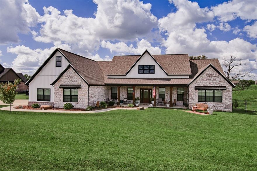 Tucked away in peaceful Moonlight Valley, this custom-built 3-bedroom plus office/flex room sits on 1.05 acres, offering hand-selected details & thoughtful design. The open concept showcases high ceilings, striking beams, exposed brick columns, brick to ceiling surround on a wood-burning fireplace & luxury wood tile floors. The gourmet-inspired kitchen features beautiful honed granite, an oversized island with clever storage, quaint farmhouse sink, charming wood plank hood, timeless backsplash, soft-close cabinetry, hidden appliance storage & a large pantry! The vaulted primary suite boasts wood tile floors, a spa-like bath with soaking tub, dual vanities & walk-in tiled shower. A hidden Murphy door bookcase with custom built-in lockers add character & plenty of storage. Outdoor living shines with covered front & back porches, a deck for sunset views, oversized 3-car garage & space to build a shop! Just minutes to I-49 offering easy access to Walmart HQ. This lovely home blends country living with convenience!