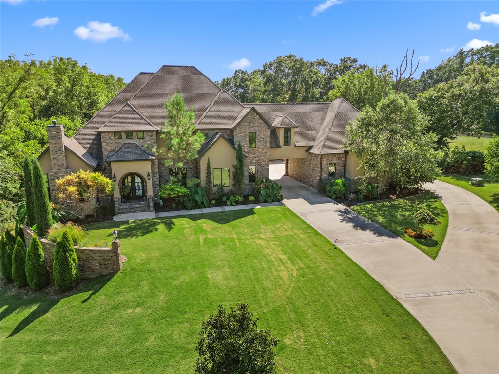 Welcome to your private 6.5 acre estate located in Talamore. An evergreen tree-lined driveway gently
curves toward the home-site. Built in 2017, this custom home offers the perfect blend of modern elegance
and serene living. An inviting 45āx20ā heated, saltwater lounging pool extending to a depth of 8ā. A private
setting, the property's meticulous details make it an exceptional place to call home. Featuring custom
hardwood floors, professional kitchen, large capacity refrigerator, warming drawer, built-in coffee maker.
Ownerās suite has two walk-in closets, spa bath with heated floors and quartz counters throughout
home. Within minutes of world class bike trails, downtown Bentonville. Conveniences include: Close
proximity to I-49, municipal & national airports. Approximately 667 ft.² included heated and cooled
space is garage bay finished as workspace with kitchen and half bath plus walkable garage storage space under the house + whole house generator. Listing includes parcels 15-16352-000 and 15-16355-000