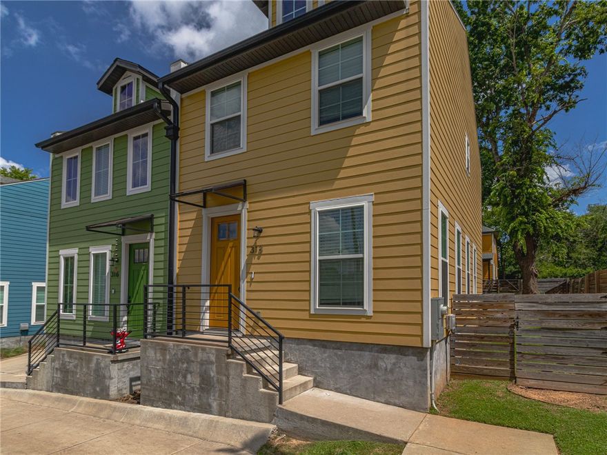 Discover this charming townhome, perfectly situated just steps from dining, entertainment, and the Razorback Greenway trail, with easy access to the University of Arkansas campus by foot or bike. Step inside to an inviting open-concept layout featuring expansive windows, soaring ceilings, and a gourmet kitchen with upscale finishes. Upstairs, find two generous bedrooms, a full bathroom with a walk-in shower, and a cozy nook ideal for a home office. Enjoy a private patio and fencded yard. Includes two dedicated parking spaces