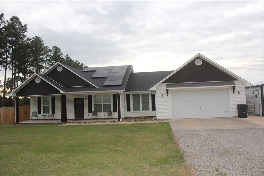 Custom-built in 2020, this beautiful 3-bed, 2-bath home offers modern luxury, generous space, and exceptional outdoor living. The manicured sodded lawn and covered porches create a warm welcome. Inside, you’ll find granite countertops, luxury plank flooring, and spacious rooms throughout. The floor plan includes a formal dining room plus a bonus room off the kitchen for added flexibility. Owned solar panels remain with the home at the listed price, providing very low electric bills (seller will negotiate removal). Exterior upgrades include concrete walkways, extended gravel parking, a detached shop, a privacy-fenced backyard, and front and back porch views of the Arkansas mountains. Meticulously maintained and just minutes from the city limits.