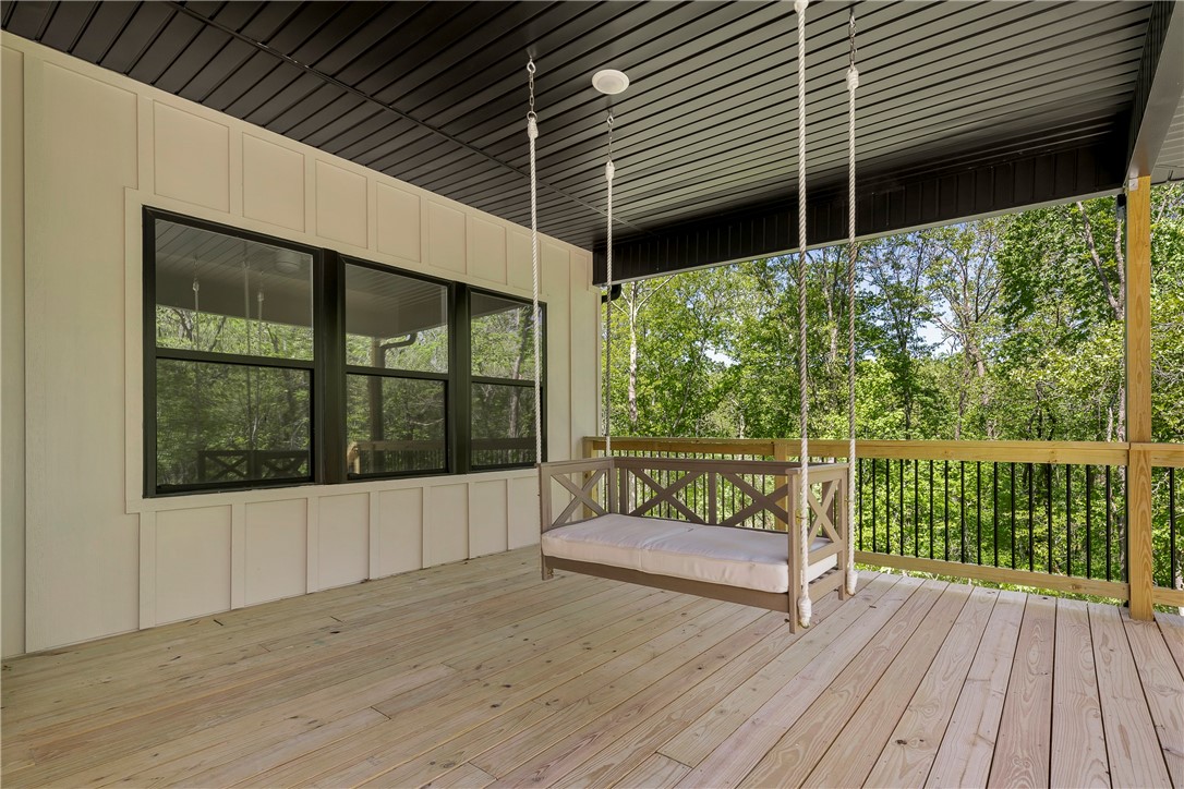 Enjoy an expansive front porch, ideal for gathering with friends or relaxing on the front porch swing. This three-bedroom home has an open floor plan, creating a spacious and welcoming family room and kitchen area. The home's abundance of windows creates an open and inviting atmosphere. Hardie board exterior siding on the front, vinyl siding on sides and back. Shiplap, large kitchen island and even a barn door. Gas/propane range. A two car garage that is extra-long w/insulated garage doors and insulated attic space above the garage. OSB Radiant Barrier roofing decking. This home has a large unfinished crawl space with double doors entry and plenty of room for all your storage needs and maybe that workshop you need. Super large primary closet has entry from the laundry room making it really convenient. French doors in the primary bedroom leading out to the spacious deck. This Home comes with a ring doorbell system. Minutes to I-49 bypass making you accessible to all of Northwest Arkansas. I dare you not to love it!