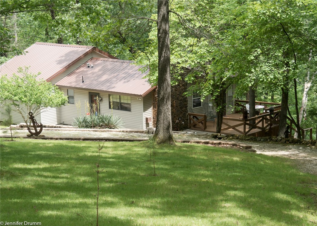 Want a charming lakefront country cottage and two acres in the woods with a dock and all utilities? On a secluded cove west of Ventris Hollow, this house offers peace and quiet on the lake with a cleared lot, circle drive, retaining walls and landscaped front yard. A fireplace and metal roof add to the longevity and charm of this lake home. 15 minutes to Rogers and shopping, trails and restaurants.
