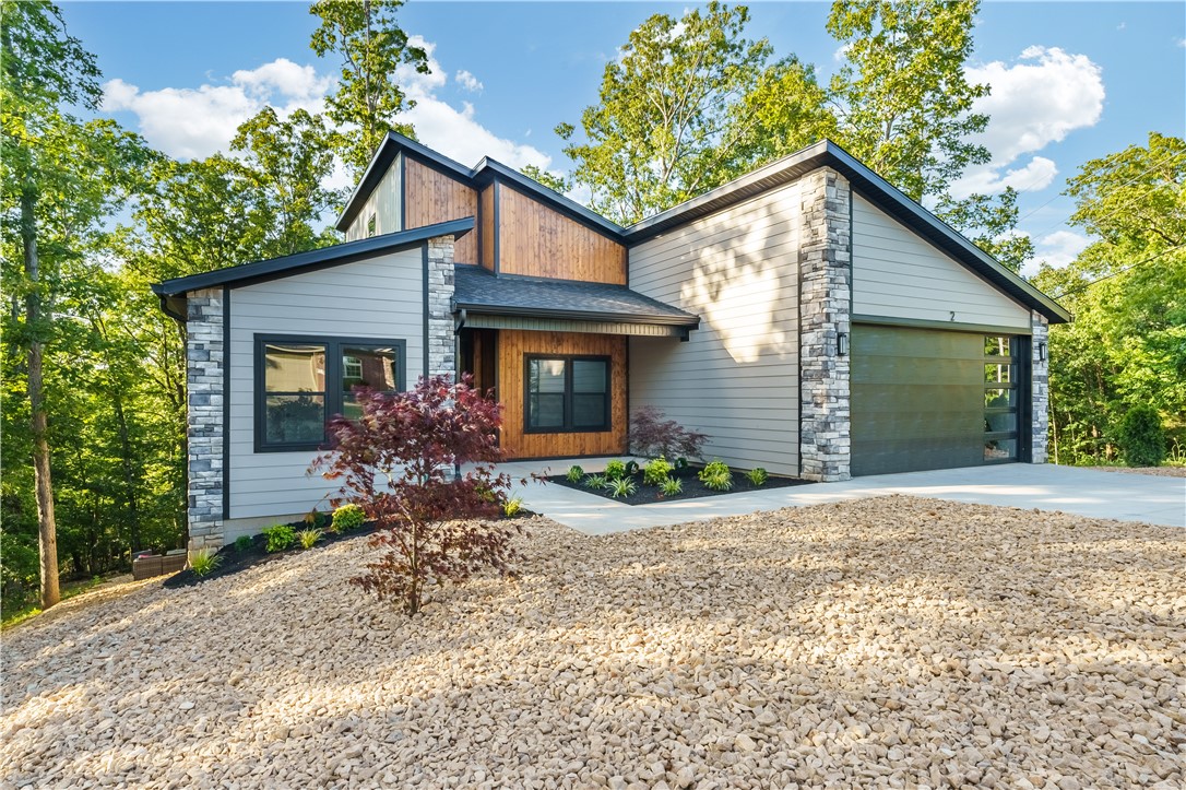 Contemporary living and architecture at its finest on a huge 0.41 acre corner lot in a fabulous location. Split floor plan including 3 bed, 2 bath home with an office all set in modern elegance highlighted by vaulted ceilings, clean lines and open floor plan with tons of natural light. This exceptional home also features a full appliance package including the refrigerator and washer/dryer. High end finishes throughout, especially in the kitchen quartz and appliances as well as huge shower and soaker tub primary ensuite. Get ready to entertain, relax, and enjoy life in a setting that feels both surrounded by nature yet close to everything. Enjoy an expansive poly-wood deck, inviting front porch and huge hard-scape yard with cool fire pit area (included). . All this set in the one of the most desirable areas of Bella Vista close to trails, shopping and short drive to conveniences including Bentonville.