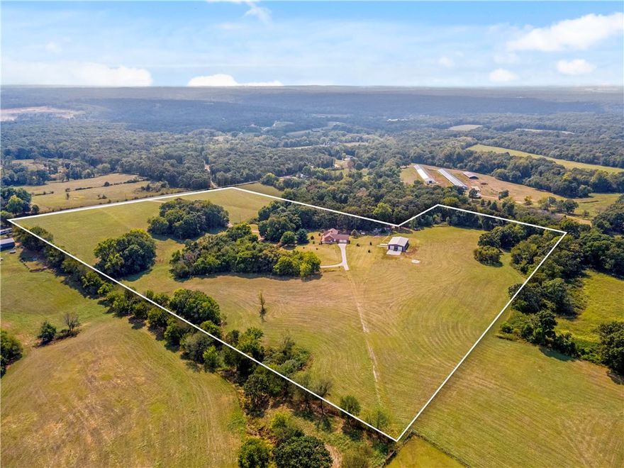 Have you been searching for the perfect place to spread out and call your own? This stunning 27 ± acre mini ranch delivers it all! Nearly 4,000 sq ft of custom living space is designed to impress at every turn. Inside, soaring cathedral ceilings and floor-to-ceiling windows flood the living room with natural light and showcase countryside views. The main level offers the primary suite plus an additional bedroom, while the lower level is its own retreat—featuring two more bedrooms, a game room, a second living area with fireplace, and a full kitchenette with island and dining space. Perfect for entertaining, multi-generational living, or hosting guests with ease.The 40x60 insulated shop is a true standout, with three garage doors, an office, full bath, and laundry. Whether you dream of a hobby farm, recreation, or the peace of country living, this property delivers. Bonus: the home next door is also available, offering a rare chance to live beside family, friends, or create your own multi-property estate.