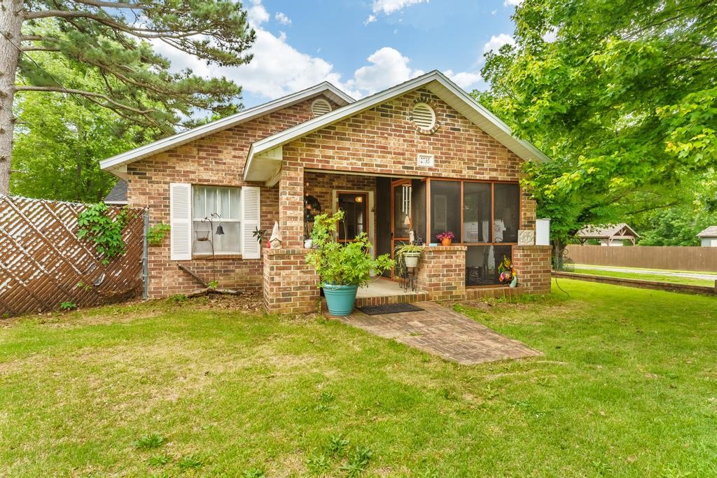 Vintage Brick Charmer with Studio, Workshop & Room to Expand. Step into timeless character and creative potential with this 1935 all-brick gem, nestled on a generous half-acre lot. Blending vintage charm with creative potential and just 9 mins to the UofA and 8 mins to the Fayetteville Square, this property offers endless potential. Inside the main house find details like beadboard, custom woodwork, and a handcrafted bar top. Screened in front porch. Beautiful sunlit heated/cooled sunroom overlooking the backyard. Original bath features a cast iron tub. Updates include new roofs on all three buildings (2021), primary bedroom insulation, attic insulation, HVAC (2018), bedroom & sunroom taken down to studs and updated, ceiling replaced. Outside: ~25’x32’ studio with garage, ~22’x18’ workshop with plumbing, ~8’x10’ canning shed, fenced garden space and 2-car carport. City planning confirmed that this property can be zoned for higher density with the secondary buildings converted to living spaces or short-term rental.