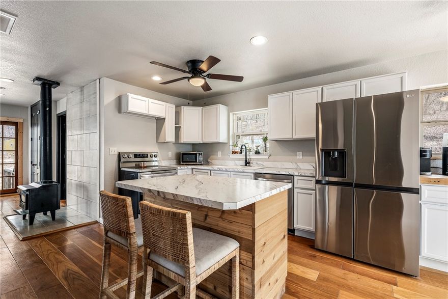 What a place to get some elbow room! Your own 12+ acres of privacy at the end of the dead end road and a charming cabin ready to welcome you home! Stylish and updated throughout, this flexible cabin offers an amazing home at an amazing price.  Wood flooring, newer cabinets and lots of windows to enjoy the natural beauty around you.  You'll love the flexible floor plan with space for a second bedroom or office and 2 full bathrooms.  Durable, metal roof and a huge deck that can extend your living space out into nature.  This spacious tract of land offers room to explore and even has a second former home site in the woods if you are interested in having a second home here.  Come see this one today, it won't last at this price!