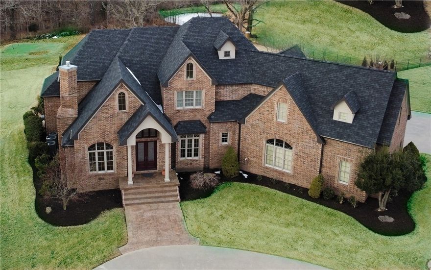 Stunning Talamore Estate! A circular drive leads you to the double front doors of the grand entry. The open floor plan provides amazing amounts of light & great views via the soaring floor to ceiling windows. A private office has a fireplace & wood built-ins for a cozy retreat. The kitchen - complete with gas range, double ovens, pantry, custom built-in china hutch, wet bar with ice maker & wine fridge - is open to a hearth room with a stone fireplace. Quality throughout with solid wood floors, inter-lock door system & a plethora of storage. 3-car sideload garage has inground storm shelter. Spacious primary suite has sitting area & walk-in closet with built-ins. Upstairs are 3 bedrooms each with their own bath. The bonus room has bar area with mini-fridge & stairs to heated/cooled finished storage area! For your outside entertainment, enjoy the 27,000 gallon pool (2021 liner) with expansive pool deck & a putting green. With over 4+ acres & more than 5,000 sqft, everyone will have plenty of space. See Amenities List