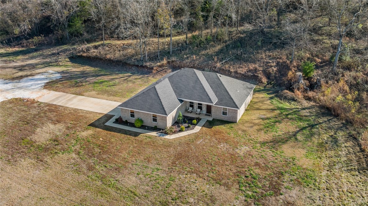 This is it! The beautiful Ozarks beckon you to fall in love with this better than new home on 4.27 acres giving you plenty of flat land to utilize however you wish and a uniquely situated plateau above that provides a unique opportunity to create your own wildlife oasis. With a gentle flowing at the front of the property, this is the quintessential Northwest Arkansas property youāve been dreaming of.
Donāt forget the 2022 built 3 bed, 2 bath split floor plan home that dazzles thru the front door with a super high vaulted ceiling inviting you into the open living area. The primary suite is large and private and offers you two walk in closets along with dual sinks and a tray ceiling. Note the beautiful granite in the perfect kitchen featuring soft close drawers, stainless steel appliances, a dining area, and a pantry space. The amply sized laundry is just icing on the cake!
Priced to sell, your Ozark dream is about to come true.