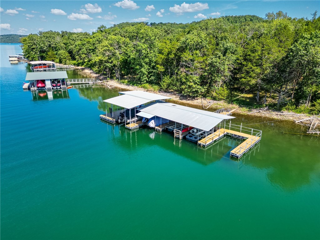 Welcome to your dream escape on Beaver Lake! This classic casual lake home offers a tranquil comfortable retreat blending its natural surroundings with STUNNING VIEWS, and is nestled in a secluded spot. Entry opens to living room with a stone wood burning fireplace, vaulted ceilings, and natural light pouring in through the windows that look out to the lake, and open kitchen. The deck offers fantastic views, & a Hot Tub. This 2,098 sqft home offers 180 degree views of the lake between Pt 6 & Pt 8, a 1,500 sqft new metal shop with 14' doors, and 2 boat slips in the community dock.(10x20 & 12x20). Recent updates include: All windows & sliders replaced, new bathroom fixtures & quartz countertops, cabinet hardware, interior completely painted, new light fixtures & ceiling fans, new KitchenAid stainless appliances, new carpet in July 2025, new shingles in the past 2 years, new gutters & leaf guards, new electrical panel for home & shop (both have 200 amp service & shop has a 50amp breaker for RV). A must see property.