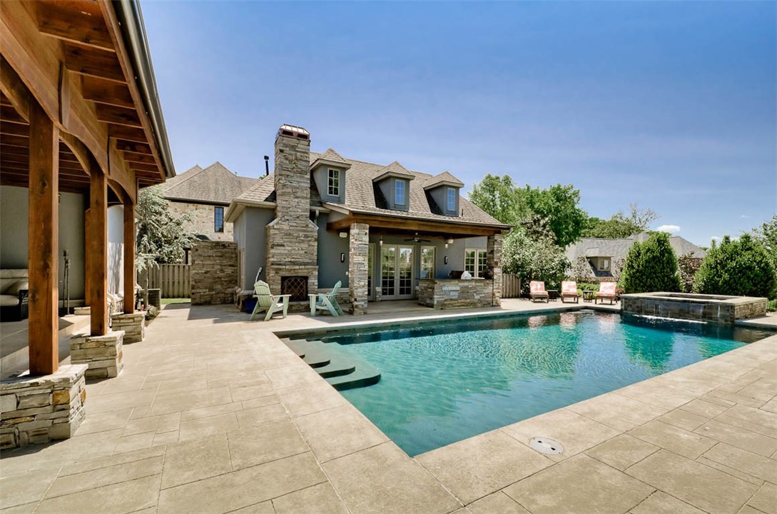Live in Your Own Private Resort! This Sophisticated, Executive Estate Home will transport you to another time and place every time you pull up the drive. Stunning, Remodeled Backyard Veranda, Pool & Jacuzzi w/Waterfall, Guest House, Open-Air Stone Shower, Master Suite Serenity Garden w/ Koi Pond, Beautiful Stone Outdoor Kitchen & Wood-burning Fireplace & Lush Landscaping Dazzles & Relaxes at the same time. Exotic, Imported Wood Cabinets in Kitchen w/All Wolfe Appliances, incl. Wine Storage will inspire