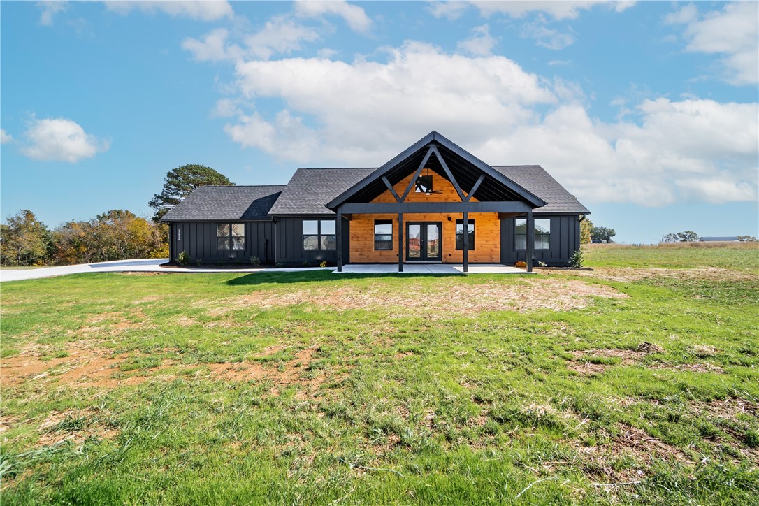 If you are looking for a luxury and convenience in one, you might want to check out this new cabin home on a quiet 1-acre lot on Guyll Ridge Road in Benton County - the best place to live in Arkansas. This home has a split-floor plan with 15-foot high ceilings and an electric log fireplace that will make you feel cozy and comfortable. The home also has luxury vinyl plank flooring that adds elegance, and ceramic tile that adds style and function. You can enjoy two outdoor living spaces: a front porch that is covered and perfect for relaxing, and a back deck that is great for hosting or enjoying the views of the countryside. This home has no POA restrictions, plenty of parking space from the side-entry two-car garage and the oversized driveway, and high quality finishes. This is a rare opportunity to own a new and beautiful cabin home.