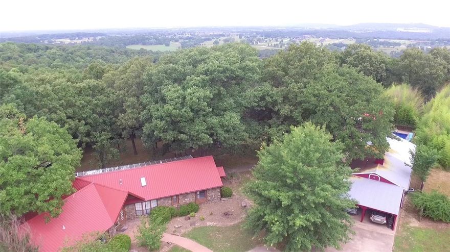Highly desirable East Fayetteville location in a park like setting minutes from downtown Fayetteville. Easy access to shopping,schools,Razorback games,I-40. Includes 4+/- wooded acres,spectacular winter view,pond,decorative waterfall/stream,private gated entrance,in-ground pool w/new liner,pool house,mother-in-law quarters/guest house. Main house has 3 beds/3 baths,loft,cathedral ceiling & wood stove. Amazing gourmet kitchen w/copper hood,island,skylight,new dishwasher,refrigerator/freezer included. Beautiful walk-in tile showers,jetted tub,gorgeous wood floors/ceilings,laundry w/washer dryer. Huge sunroom w/HVAC,wrap around rear deck,large oaks/fruit trees. No city sewer or water bill! The shop/carport provides room for your lawn tools. Owner has completed extensive updates, repairs and cosmetic improvements throughout the property. This hidden gem is right around the corner from Sassafras Springs Vineyard and Winery & on market for the first time in over 20 years. This won't last long call for your showing today!