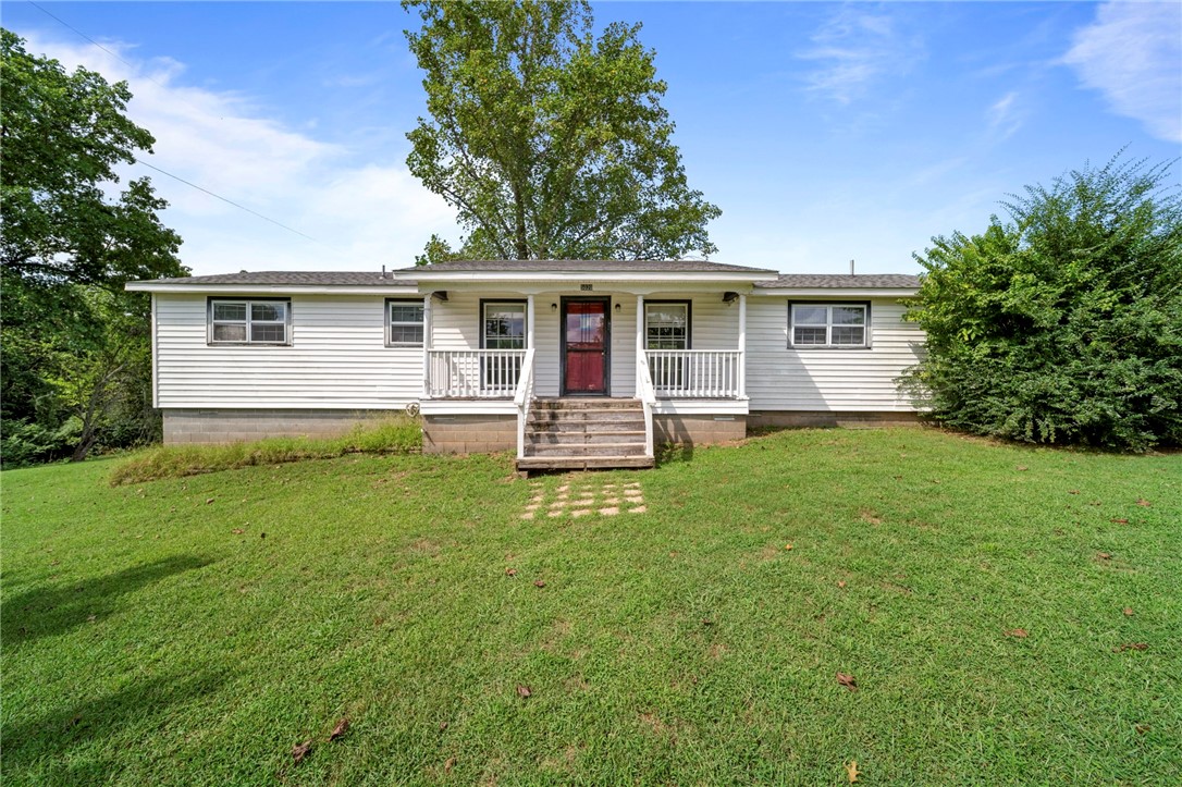 With a little love, this home could be your homestead. Nestled on a serene 1.46-acre lot, 5020 E Wyman Road offers the perfect balance of rural tranquility & city convenience, just 15 minutes from the University of Arkansas, downtown Fayetteville, Lake Fayetteville, & the Northwest Arkansas Mall. This charming property features a spacious living room filled with natural light, a kitchen with abundant cabinet storage, & a separate utility room for added functionality. Step outside to enjoy the expansive 720 sq ft deck, ideal for entertaining, relaxing, or simply taking in the peaceful, wooded surroundings. With room to roam & the convenience of city amenities close by, this home is a rare find in a desirable location. Home will be sold AS IS.