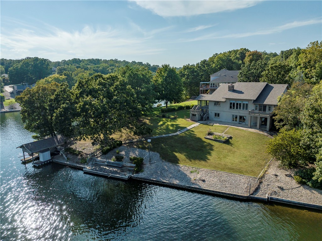 Loch Lomond lake front w/ swimming, great fishing, kayaking, paddle boarding, & motor boating. All launched from private dock & 206 ft of shoreline. New roof & water heater 2019. Main floor; Living Room w/ vaulted ceilings, large picture windows offering stunning lake views & double gas-log fireplace between living / family room. Kitchen w/ spacious cabinet space, pantry, Jen-Air cooktop & open to dining / family room. Primary suite w/ private deck space, large bathroom & spacious 16x6 walk-in closet. Enjoy view & nature from the screened in porch. Second floor; 2 Bedrooms, 1 bathroom & family room. Walk-out Basement; Kitchenette, 2nd Living Room w/ pool table, Office space (could be used as 4th bedroom), 192 square ft (included in square footage) heated / cooled workshop. All w/ stunning views from windows or outside patio space. Central Vac for all 3 levels, mature landscaping & 3 bedroom septic. Seller offering flooring concession $25,356.19 / swim dock concession $4,581.60 / deck concession $34,456.28.