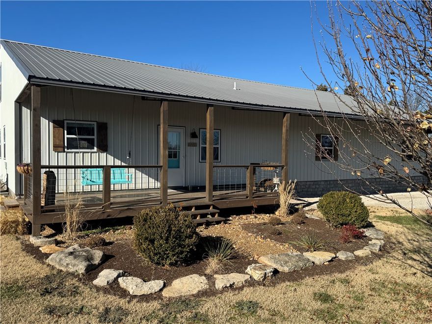 Experience peaceful Ozark Living in this beautifully designed barndominium situated on 5+ acres in the desirable Meadows subdivision, just minutes from downtown Berryville.  This low-maintenance home features durable metal siding and roofing, radiant-heated stained concrete floors, and a spacious open concept layout designed for comfortable country living.
The kitchen is equipped with cherry cabinetry, stainless steel appliances, and generous counter space. The main level primary suite includes a walk-in closet and private ensuite bath, along with a convenient half bath and an oversized laundry/mudroom.
Upstairs, you'll find 2 large bedrooms and a dedicated children's library or playroom, providing plenty of space for family or guests.
An outdoor wood furnace efficiently supplies heat to the water heater and radiant flooring system. The fully fenced property and includes a 40x40 insulated shop/garage with foam insulation, automatic overhead door opener and workbench  New HVAC installed  1/2026 and home warranty.
