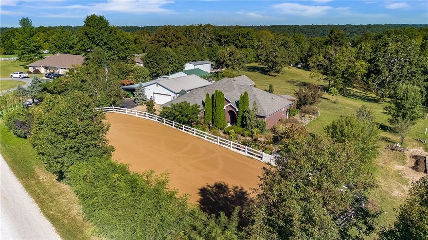 Experience the perfect balance of comfort, function, and country living with this all-brick 4-bed, 2.5-bath home on 5.31 picturesque acres with a pond. Built in 2006, this property is a horse owner’s dream, featuring a 2–3 stall barn with a full fly-control system, hay barn, tack building, and a fully plumbed, drained dressage arena desigend for training & performance. The home offers an open floor plan with formal dining, a spacious eat-in kitchen with granite counters, and abundant storage. Upstairs includes a bedroom and half bath ideal for a second living area, playroom, or office. Enjoy peaceful views from the large back deck, screened detached sunroom, cozy gazebo with firepit & seating area. Additional features include three shops, four garage spaces, 46’ covered RV and trailer parking, and a 2-bed, 1-bath guest house located inside one of the shop buildings. A whole-home backup generator provides peace of mind. This exceptional property combines country charm, equestrian amenities, and everyday comfort.