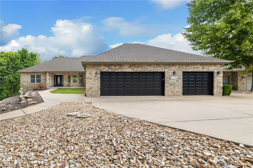 Stunning lake-living lifestyle retreat situated on nearly a half acre park-like lot.  This home has been refreshed with new carpet throughout and all exterior doors have been newly painted.  Located on a quiet cut-de-sac with easy access to Lake Lock Lomond, you are steps away from a public boat launch, world-class hiking and biking trails.  The open floor plan is bathed in natural light, featuring a sunroom with large windows that capture year-round partial lake views.  The main level offers a split bedroom layout, while the finished walk-out basement presents and incredible opportunity for an AirBnB or mother-in-law suite, complete with a full second kitchen and a private entrance.  Outdoor living is a dream here, with 4 spacious decks, a gas fire pit, over-sized 3 car garage, a 245 sq ft heated and cooled and massive unfinished storage space.  From the modern interior updates to the incredible income potential, this home offers the best of Bella Vista living.