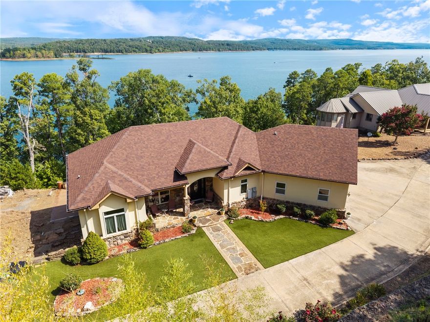 Welcome to your dream retreat on beautiful Greers Ferry Lake in Bee Branch! This luxurious lakefront home is filled with warmth, character, and high-end finishes—from inlaid floors to custom cherry wood trim, and cabinetry. The open floor plan offers bright, spacious living with breathtaking lake views from nearly every room. A sweeping staircase connects two inviting living areas, each with its own fireplace. Enjoy movie nights in the theater room and host with ease in multiple entertainment spaces. The walk-out basement opens to a large patio—perfect for lakeside gatherings and sunsets. A gourmet kitchen with generous pantry makes entertaining effortless, while the built-in tornado/storage room provides peace of mind. Nearby boat launch and storage make lake life easy—bring your boat, jet skis, and water toys! Just 20 minutes from Sugar Loaf Park and Hwy 65. 2x6 construction, spray foam insulation, new roof 2025, newer DW & fridge, oversized 2-car garage (700+ sqft). Lake living at its finest.
