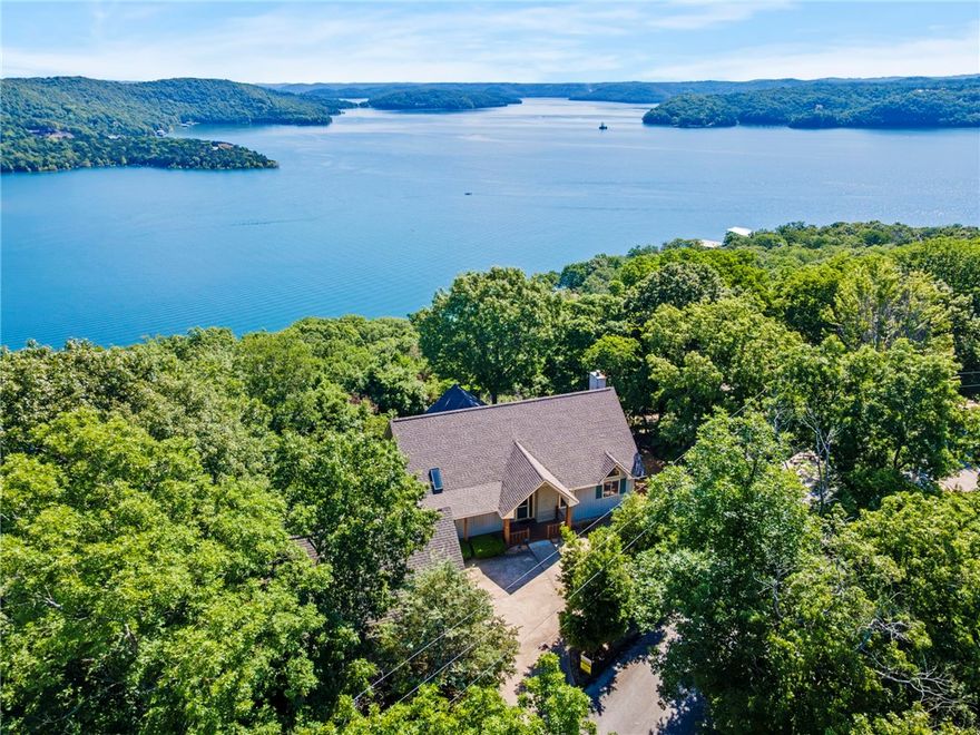 Wow! Expansive, year-round Beaver Lake view home perched up above the trees in Lost Bridge Village. Well maintained w/very functional floor plan! Open concept main level w/cathedral ceilings in great room & gas fireplace flanked by built-ins. Walk out to either the open deck or the screened porch. Plenty of kitchen cabinet storage! Primary bedroom w/5-piece bath, walk-in closet & another slider to go enjoy the outdoor living areas. Lower level also has great lake views, along w/2 more bedrooms, full bath, laundry room, family room w/mini wet-bar & gas fireplace.  Lower level workshop area could easily be converted to a 4th bedroom. Two more walk-outs to the lower deck & one to the side yard & storage shed. 2-car detached garage w/upstairs bonus room that would make a great workout room, office, craft room, etc. Home buyer has first right to purchase pontoon boat ($8,000) & transfer the 24' slip lease in Lost Bridge Marina...just minutes away & adding to the appeal of lake life! Must see to appreciate those views!