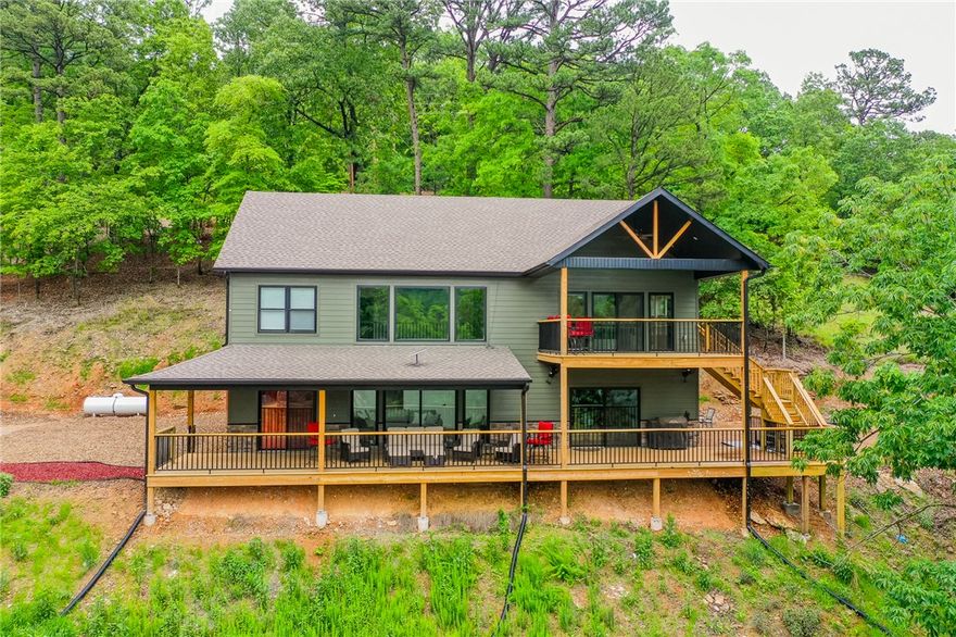 Stunning lakefront retreat on Beaver Lake's Clearpoint Cove! Expansive windows and soaring ceilings flood the home with natural light and frame breathtaking water views. Whether you're in the kitchen, living room, game room, or out on the deck, the lake is always the star of the show. Thoughtful design w/ 3 bedrooms (2 ensuites), a bunk room, & 3.5 baths. Features include: quartzite countertops, a gas range, & double ovens, 2 decks, game room, hot tub, fire pit, & a co-owned dock complete with a swim deck for easy lake access. Gentle walk to the shoreline makes enjoying the water effortless. Bordering Hobbs State Park, this property offers not just a home, but an outdoor experience with hiking and nature at your doorstep. Whether you're looking for a full-time residence, weekend escape, or investment opportunity, this lakefront haven delivers. Schedule a showing today!