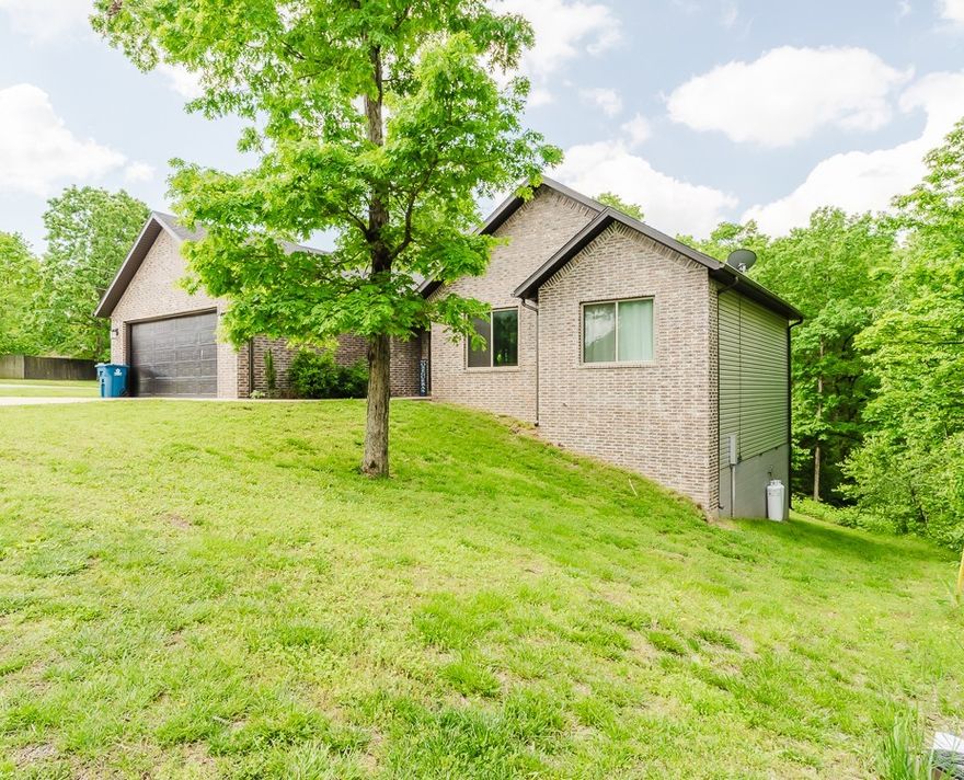 A spacious yet modern 3 bedroom, 2 bath, 2 car garage home on a nice corner lot. Minutes to Lake Ann and right on the back 40 biking trails for walking or biking. Engage in all the POA amenities Bella Vista has to offer- Pools, club houses, parks, lakes, golfing & more. This home features a split floor plan with large cathedral ceilings and high beam accents. Open living area with great lighting and large windows with wooded views. Beautiful white finished cabinets, stainless steel appliances, gas cook top and black custom granite counters. Wood flooring through out home with formal dining area. Primary bedroom and bathroom leading to a walk in tile/glass shower- double shower heads, dual sink vanities and capacious walk in closet. Large covered back deck to enjoy with an outstanding wooded view.