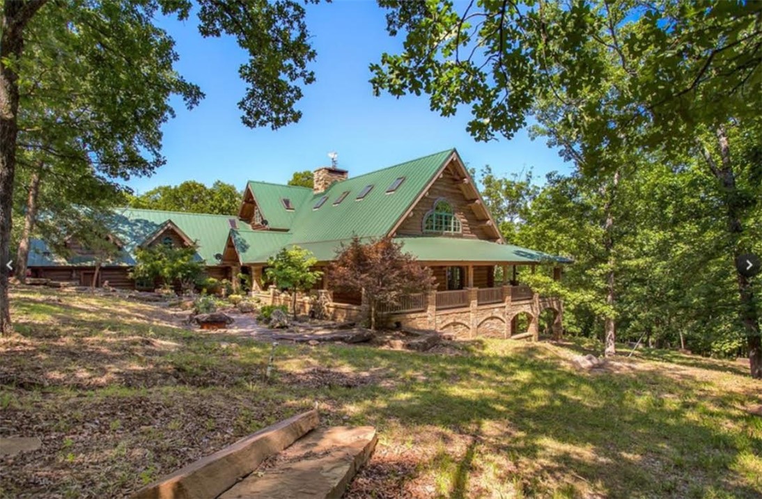 Incredible 224-acre estate w/over half a mile (~3500ft) of White River frontage—just outside Fayetteville. A nature lover’s & sportsman’s paradise w/wildlife, two ponds & breathtaking views. The 9,920sf custom log lodge features hand-hewn logs, custom doors, 5 stone fireplaces, stacked stone exterior, geothermal heated floors, metal roof & elevator. Inside: 4 beds, 5 baths, loft & safe room/full separate apartment. Massive 44’ x 36’ great room is perfect for entertaining, events, or retreat use. Over 3,800sf of covered porches, balconies & patios provide seamless indoor/outdoor living. Also on the property are 2 guest homes (~1250sf each, not included in listed square footage), a tiny cabin, greenhouse, barns, goat & horse stables, chicken coops, metal buildings & original homestead water well. Fenced & cross-fenced. Endless potential as a private estate retreat, working farm, or event venue. City water/electric. Built in 2002 with exceptional craftsmanship. Sold as-is, some finishes required. Appointment only.