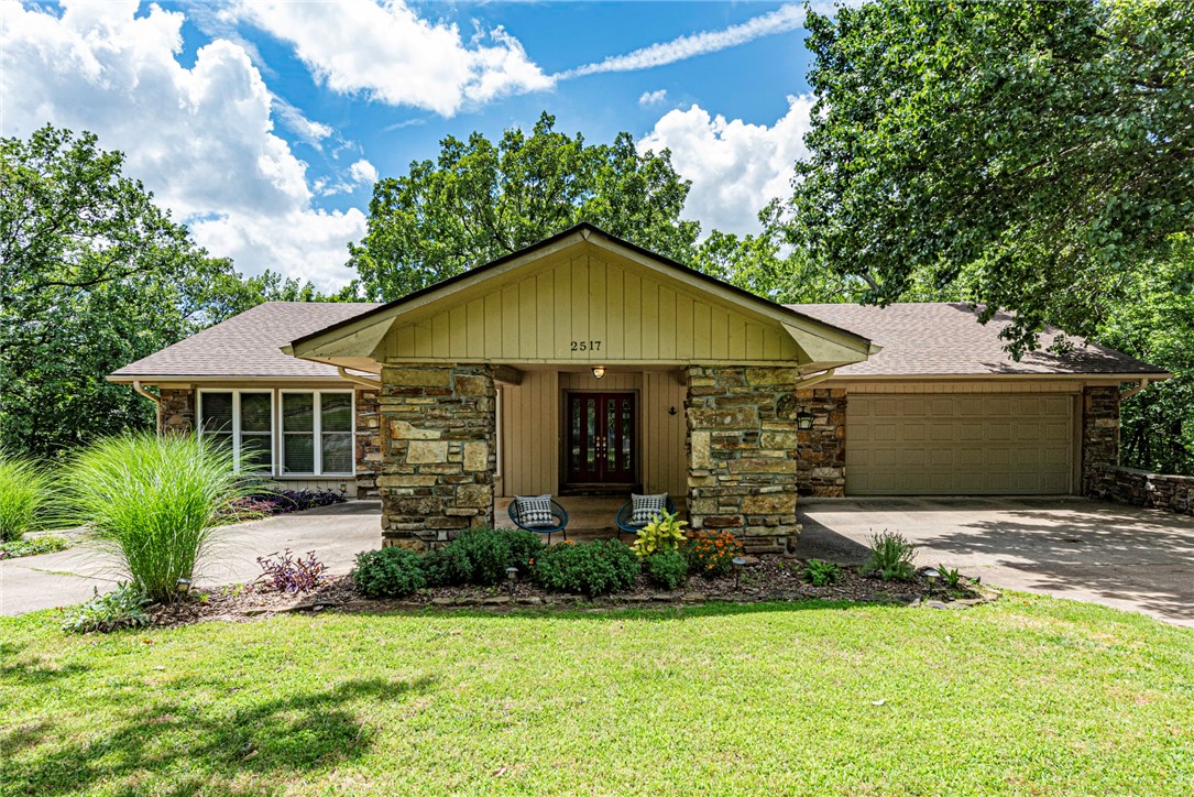 Live in the middle of Fayetteville but feel as if you're in the country surrounded by a wall of mature trees. A welcoming and spacious floor plan on two levels with large windows and plenty of sunlight gives beautiful views of the sunset and Fayetteville's lights in the fall and winter. The upper level's main room with a wood-burning fireplace leads out onto a glass-enclosed reading nook with the feel of a treehouse. The primary suite is spacious as it overlooks the yard with nearly floor-to-ceiling corner windows. The downstairs level boasts a family room with large bookshelves, a wet-bar, a workout or yoga room and a very large storage area that doubles as a storm shelter. Walking out of the basement you will see a glass, closed-in sunroom with large outdoor deck. This home is just five minutes from the main attractions in Fayetteville from Gulley or Wilson Parks to the University of Arkansas, Dickson Street, the Fayetteville Square with its farmerās market, the mall and shopping areas, and Lake Fayetteville.
