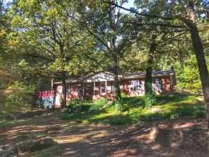 Don't miss out on this home nestled in the trees! Beautiful scenery surrounds a lovely home in Atkins. This home offers three bedrooms, two full bathrooms, a beautiful fireplace, and a large office. Enjoy fall mornings on your deck with the surrounding wildlife. Outside, you'll also find a wet weather stream, an outbuilding, all this on over 3.5 acres!