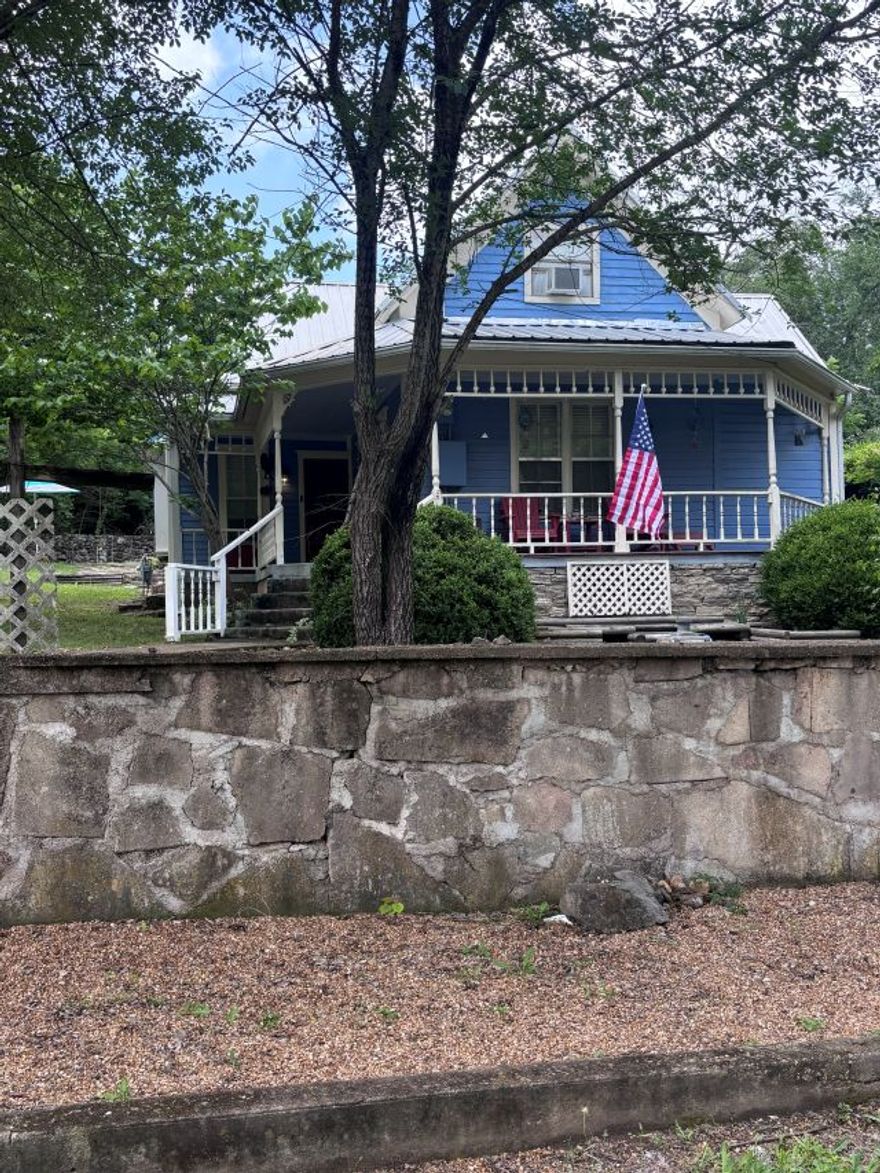 Sitting on a corner lot in the City of Yellville, this home with timeless charm, showcases a wraparound front porch with decorative trim, classic railings, and architectural detail that hint at its historical roots.  Beautifully remodeled and renovated, the home offers a blend of character and modern comfort.  This spacious home is thoughtfully designed with the living area, dining, kitchen, laundry, two bedrooms and two full bathrooms on the main level.  Upstairs hosts two bedrooms and a bonus room perfect for media space, game room or home office. The detached one car garage and storage shed offers plenty of space for vehicles, lawn equipment, hobbies and storage.  Situated on three city lots there is plenty of space outside for entertainment, gardening, expansion possibilities or just enjoying the privacy. A rare opportunity to own a piece of history with updated features and plenty of space, this unique property is full of charm and move in ready.