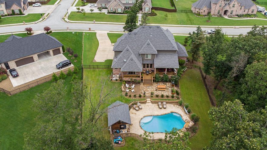 Fantastic Backyard Oasis in Oak Tree!  Sitting on a 2 acre wooded lot featuring Custom-built Heated Pool with Waterfall and Tanning Ledge, Covered Cabana, Firepit and Extensive lush landscaping!     Home features over 5000 sfeet, 5 BD (2 on main level), 4 full baths, 2 half baths. Stunning Grand Entry w/curved staircase, Media Room equipped with 100" electronic screen & wet bar, Game Room, Gourmet Kitchen, Butler's pantry, Designer baths, Wood Paneled Library.   Oversized 3 car garage, and TONS of storage space.  Outdoor additional amenities include 2 covered porches, outdoor kitchen, grill, and extended flagstone patio.   Never leave home, as this home has it all!