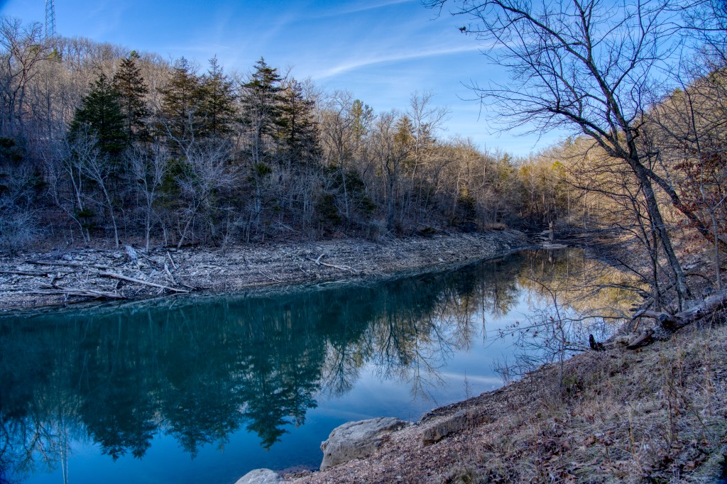 This 7.5 acre piece of land is made up of three tracts at the end of the road that would be perfect for a lake front cabin in the woods! This large parcel has 660 feet of lake frontage in the back of the cove and has enough room, and a new gate, to assure privacy. A wet-weather waterfall, cliffs and boulders make for a peaceful environment! This property has several building sites on it and more than one structure could be built. This land is unrestricted and has two septic permits. Agent Owned.