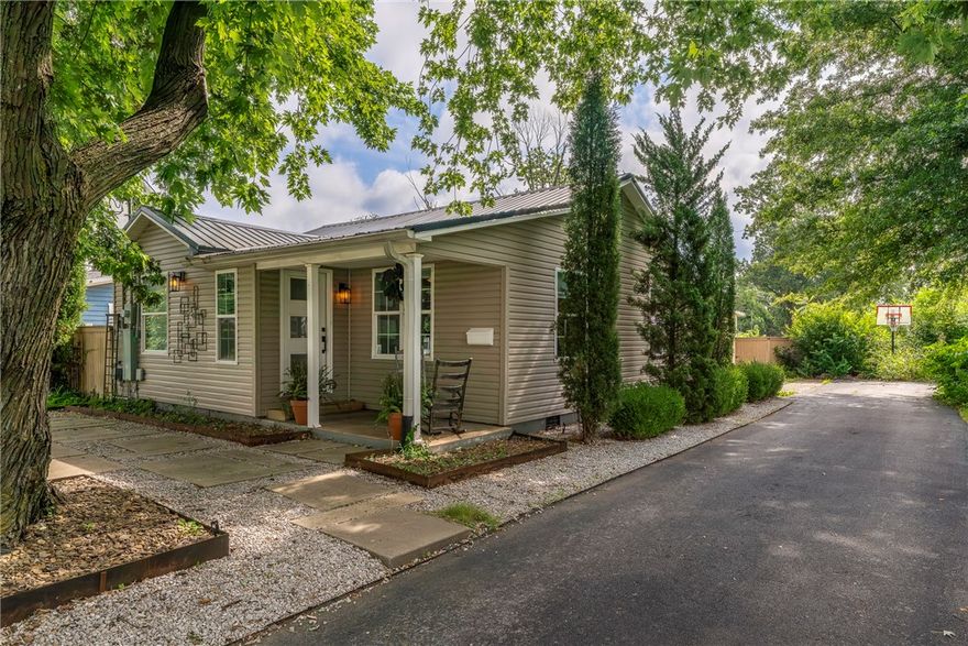 Adorable Bentonville cottage just 6 blocks from the Square—prime location with serious potential. Whether you're dreaming of an second home, Airbnb, long-term rental, or future build, this one checks the boxes. The lot alone is worth the asking price. Side alley access, a large 1-car garage + carport = rare storage for bikes and gear. Quiet street with direct access to Park Springs Park and world-class mountain biking trails. Inside: 3 beds, 2 baths, hardwoods throughout, and a spacious primary suite with ensuite bath. Metal roof, towering shade trees, and walkable to Airship Coffee and all things downtown. Biking capital, food mecca, art hub—this is the heart of it all.