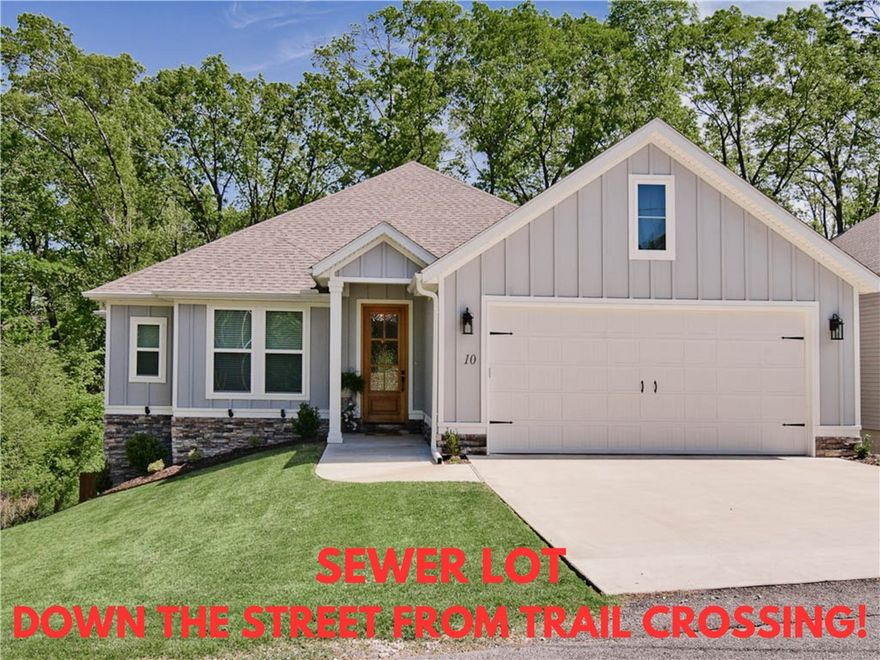 Welcome to this impeccably maintained home built in 2023, offering breathtaking wooded views! Sewer lot! Situated just down the street from the Uphill Both Ways Trail Crossing and within very close proximity to Lake Windsor, Lake Avalon, Tanyard Creek, and the OZ Bike Lift. Step inside to discover beautiful hardwood floors throughout, including in the primary bedroom and guest bedroom / office. The primary bath boasts a soaking tub, a spacious custom tile shower, and an expansive closet for all your storage needs. 3 bathrooms! Enjoy the grandeur of cathedral ceilings in the living and beautiful custom cabinets in the kitchen, complete with a large pantry. Laundry room is massive and features tons of cabinets and a sink. The home is adorned with custom finishes throughout, enhancing its appeal. Relax on the huge covered patio with a wood ceiling or utilize the extensive storage space below the home. The fenced-in backyard offers plenty of space for outdoor activities. Bentonville schools!