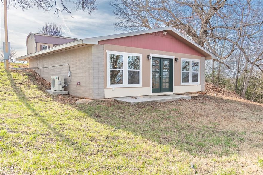 Recently remodeled berm home situated on approximately 1.88 acres with beautiful Ozark views! This 2 bedroom, 1 bath home offers an open floor plan and energy-efficient design with large windows that bring in natural light and capture the surrounding scenery. The updated kitchen features attractive cabinetry with soft-close doors and drawers, solid surface countertops, and great workspace. The bathroom includes a spacious walk-in shower, and both bedrooms feature stylish barn door closets. A charming detached bungalow with 1 bedroom, full bath, and kitchenette provides additional living space for guests or potential rental income.  Located near Bull Shoals Lake and area trails, this property offers a peaceful setting with plenty of opportunity for recreation and relaxation.