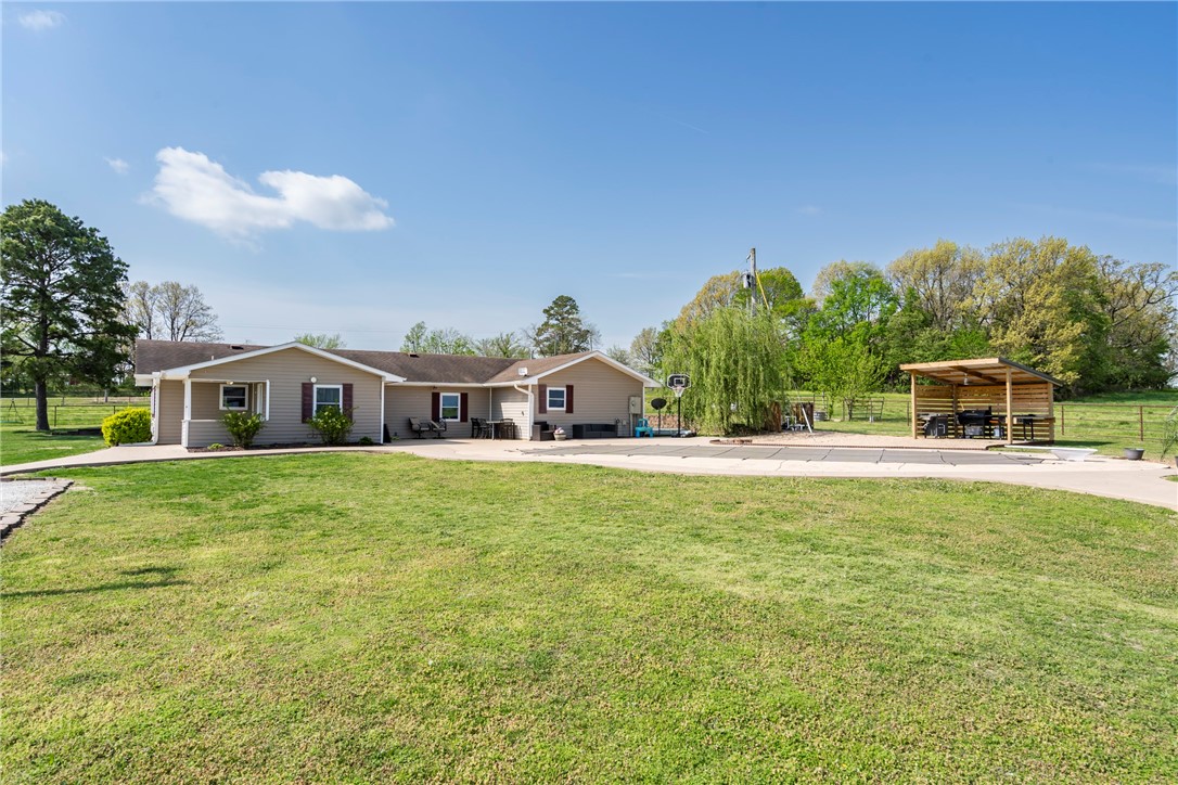 The place to be! Country living while only being 4 miles from town. This 1822 sq ft home features 4 bedrooms/2 bathrooms, an eat in kitchen, stainless appliances, & new LVP flooring. The covered porch on the back of the house opens into the mud room/laundry room which is a great landing spot when coming in from the pool or the barn. There is a beautiful in ground pool with a diving board & an inflatable slide, as well as a covered outdoor kitchen area. Next you will want to explore the over 2100 sq ft metal pole barn with 2 storage/feed rooms, an incredible hangout room, and an area for animal stalls. All of this sitting on 4 acres m/l, (exact acreage to be determined by survey).